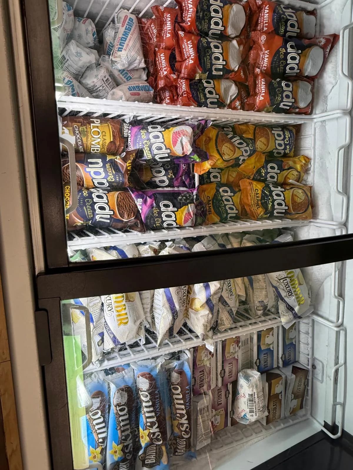 A refrigerated case filled with European sausages and cured meats